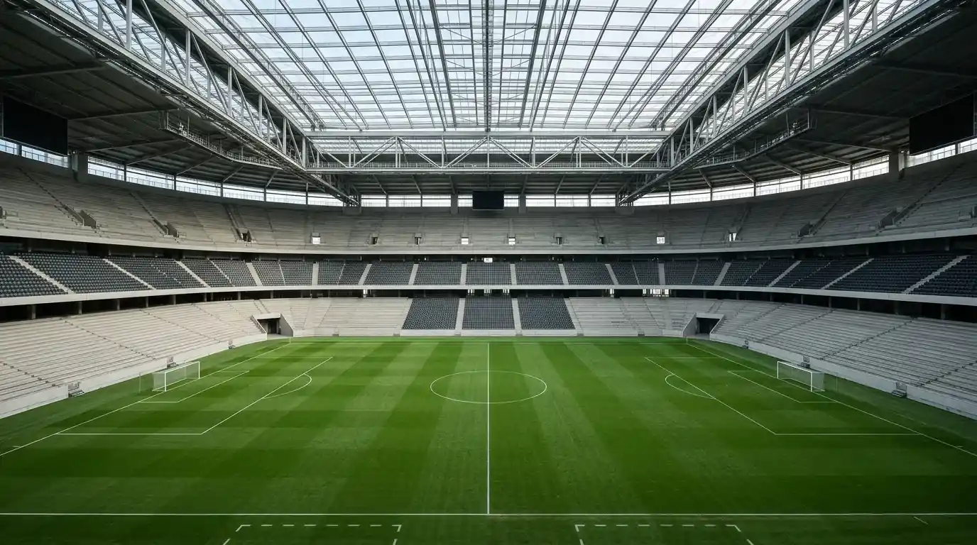 Innenraum eines modernen überdachten Fußballstadions mit sattem grünen Rasen und leeren Rängen